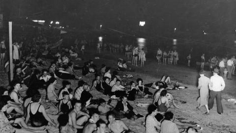View of Glenelg Beach taken on a hot February night showing bathers seeking relief from the heat.