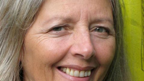 A women with silver hair and smiling blue eyes.