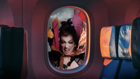 Sunny Young in an airplane window in drag make up