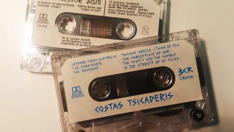 Two cassettes out of their covers. One reads "Costa Tsicaderis", and the other "Nestor Agis", along with track listings and other information.