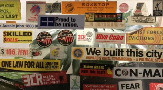 3CR kitchen window of campaign stickers about all things work and solidarity.