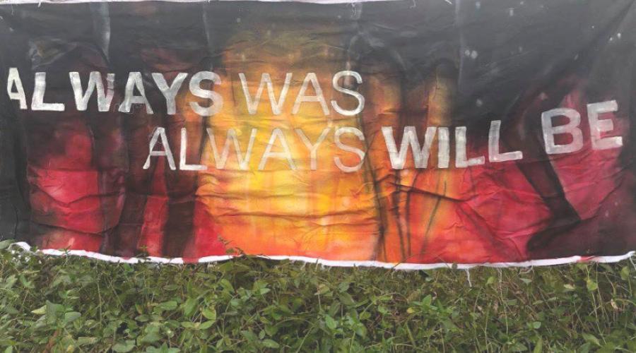 A banner that's painted in the aboriginal flag colours. The banner says Always Was Always Will Be